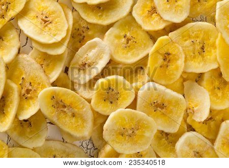 Heap Of Dried Banana Chips Snack On White Rustic Table Top View