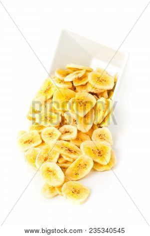 Heap Of Dried Banana Chips Snack In White Bowl Over White Background