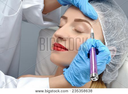 Microblading. Cosmetologist Making Permanent Makeup. Attractive Woman Getting Facial Care And Tattoo