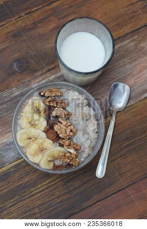 Breakfast With Granola Bowl, Muesli With Oats, Nuts And Dried Fruit, Milk, On Wooden Table. Bannana,