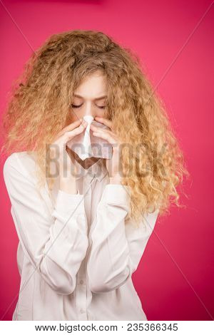 Close Up Portrait Of Young Lady With Unruly Hair Sneezing To The White Handkerchief. Female Is Ill. 