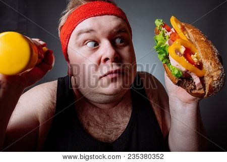 Fat Sportsman Has Ruined The Diet With Yummy Humburger. Gluttony.