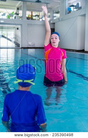 Swimming Lesson. Cute Little Boy Learning To Swim With Swimming Instructor