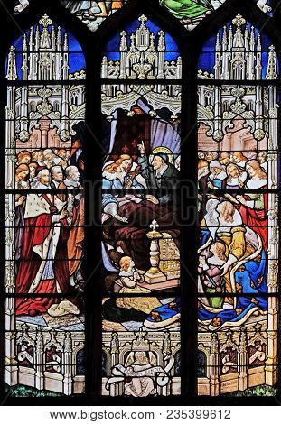 PARIS, FRANCE - JANUARY 04, 2018: The death of Louis XIII in the presence of St Vincent de Paul, Anne of Austria, the future Louis XIV and Cardinal Mazarin, stained glass in St Severin church in Paris