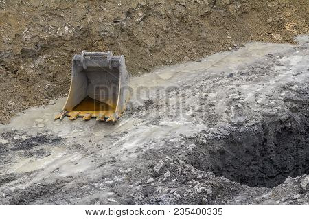 A Old Dredger Bucket On Loamy Ground