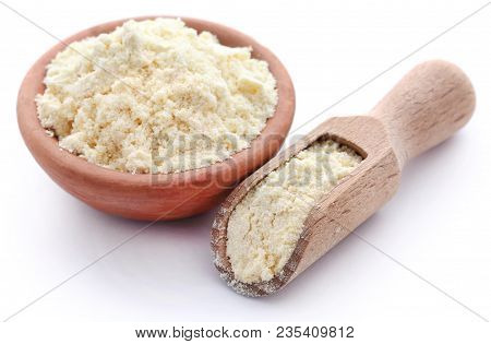 Gram Flour In Bowl And Wooden Scoop Over White Background