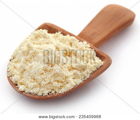 Gram Flour In Wooden Scoop Over White Background