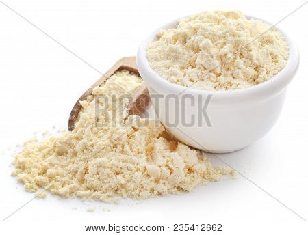 Gram Flour In Bowl And Wooden Scoop Over White Background
