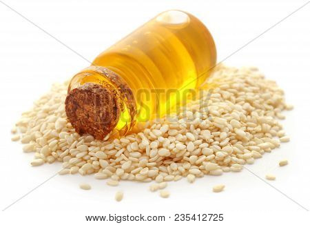 Peeled Sesame Seeds With Oil In A Small Jar Over White Background