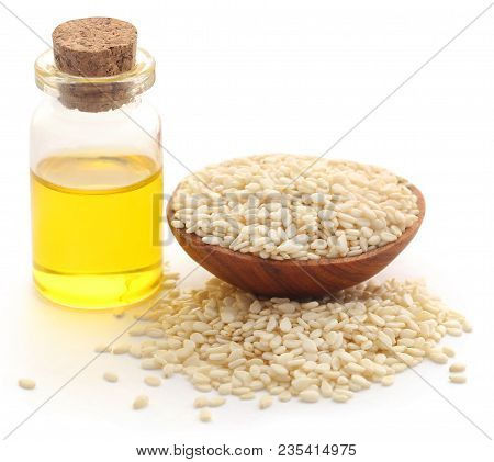 Peeled Sesame Seeds With Oil In Bottle Over White Background