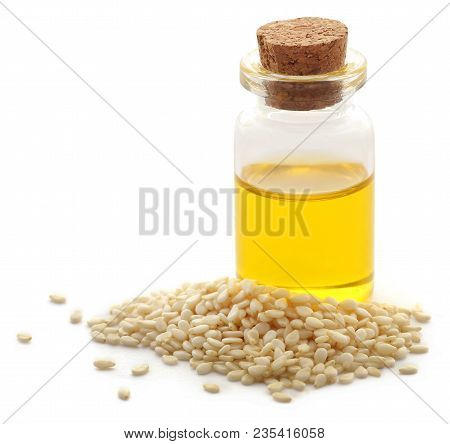 Peeled Sesame Seeds With Oil In A Small Jar Over White Background