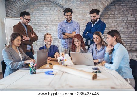 Business, Technology And Office Concept - Business Team On Meeting In Modernoffice Interior And Work