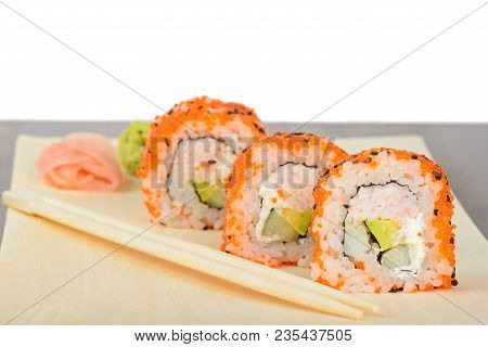 Closeup California Maki Sushi With Masago On The Wooden Plate. Roll Made Of Crab Meat, Avocado, Cucu