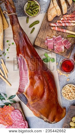 Appetizers Table With Spanish Iberian Whole Ham Jamon Serrano, Snacks, Olives And Red And Rose Wine.