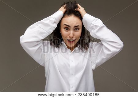 Beautiful Girl In A White Shirt Shows Emotions. On A Light Background.