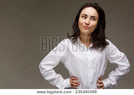Beautiful Girl In A White Shirt Shows Emotions. On A Light Background.