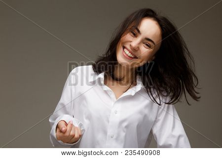 Beautiful Girl In A White Shirt Shows Emotions - Smile, Fun. On A Light Background.