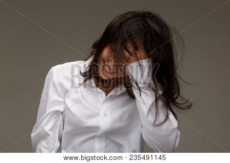 Beautiful Girl In A White Shirt Shows Emotions - Smile, Fun. On A Light Background.