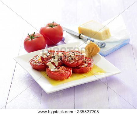 Baked Tomatoes With Parmesan Cheese And Olive Dressing.