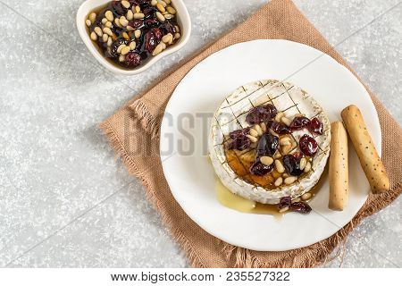 Brie Cheese Baked With Cranberries And Nuts Sauce. Served With Bread Sticks With Flaxseed