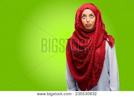 Young arab woman wearing hijab making funny face fooling