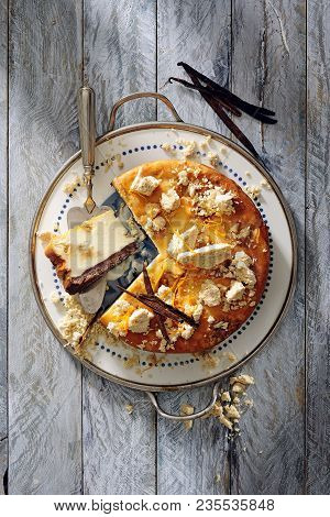 Baked Halvah Cheesecake Topped With Pieces Of Halvah And Vanilla Sticks