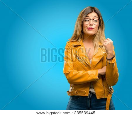 Beautiful young woman making funny face fooling, blue background