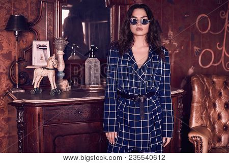 Beautiful Elegant Woman Dressed In A Blue Checkered Suit In Red Interior