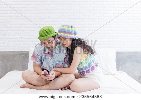 Couple Asian Man And Woman With Woolhat Together Funny Moment On White Bed