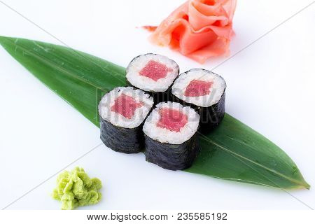 Delicious Fresh Mini-rolls With Tuna On A Banana Leaf. Sushi Rolls On A White Background With Ginger