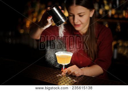 Female Bartender Serving A Fresh Delicious Yellow Illuminated Cocktail And Pouring A Spice Into It O