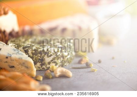 Assortment Of Hard, Semi-soft And Soft Cheeses With Olives, Grissini Bread Sticks, Capers, Grape, On