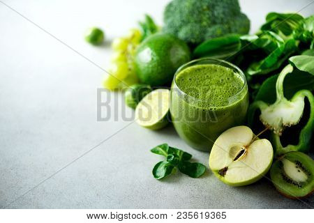 Glass With Green Health Smoothie, Kale Leaves, Lime, Apple, Kiwi, Grapes, Banana, Avocado, Lettuce. 