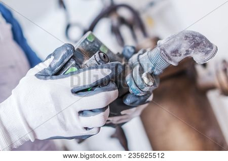 Plumbing Service Work. Plumber With Some Hydraulic System Part In Hand. Closeup Photo