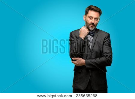 Middle age man, with beard and bow tie with crossed arms confident and serious