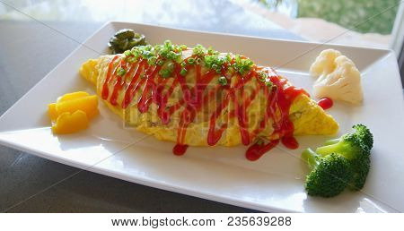 Egg Omelet Roll With Vegetables
A Huge Egg Omelet Roll With Vegetables Topped With Ketchup Stripes A