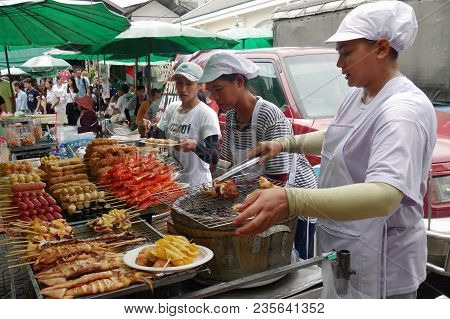 Bangkok, Thailand--street Food Vendors Busy Grilling A Wide Array Of Seafood And Other Ready To Eat 