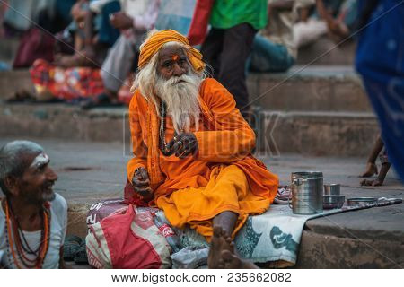 VARANASI, INDIA - MAR 29, 2018: Sadhu or Baba (holy man) on the ghats of Ganges river. Normally a sadhu is a monk, renounced, renounced material enjoyment. In India from 4 to 5 million sadhu.