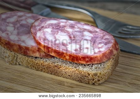 Two Pieces Of Sausage On A Piece Of Bread
