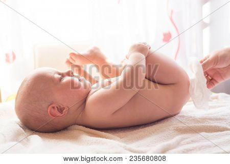 Hygiene - young momy wiping the baby skin with wet wipes. Cleaning wipe, pure, clean