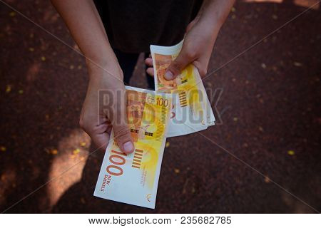 Monetary Sheqel In Hand Against The Background Of A Person