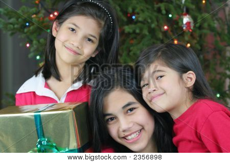 彼らのクリスマスを保持して 3 つの幸せな姉妹を提示します。