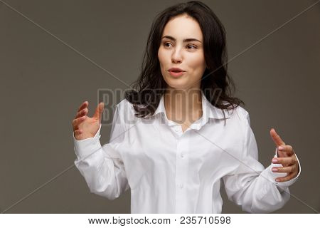 Beautiful Girl In A White Shirt Shows Emotions. On A Light Background.