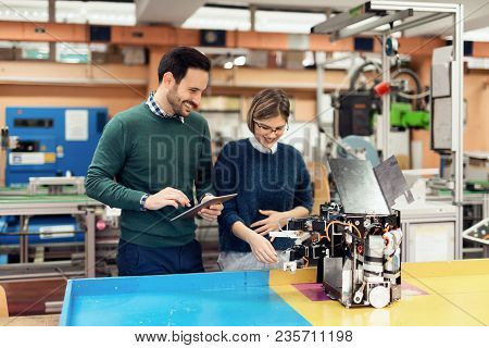 Young Attractive Students Of Mechatronics Working On Project Together