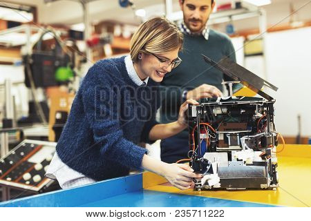 Young Attractive Students Of Mechatronics Working On Project Together