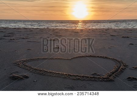 Beautiful Sunset At The Beach With Wooden Piles And Hearts Drawings In The Sand Petten, Holland, Nor