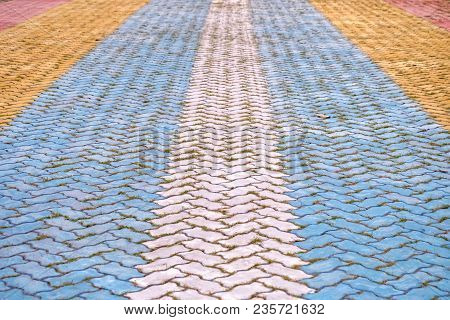 Multicolored Painted On A Hard Cement Ground Floor Of Walkway With A Row Of Brick Blocks For Backgro
