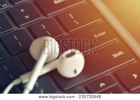 Headphones On The Keyboard. Online Straming Music Service Concept. Focus On Keyboard