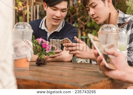 Group Of Teenager Adding Friend Play Social Media With Smartphone Together In Coffee Shop