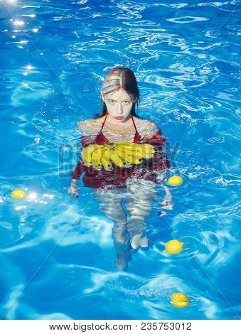 Vitamin In Banana At Girl Sitting Near Water. Woman With Tropical Fruit In Pool. Woman Relax In Spa 